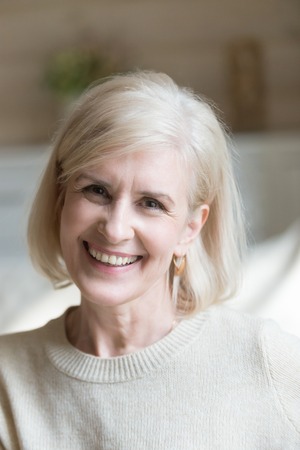 Close up of smiling aged woman feel positive and energetic looking at camera making picture,...