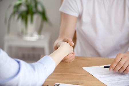 Close up of woman shake hand of real estate agent buying house and signing contract, client...