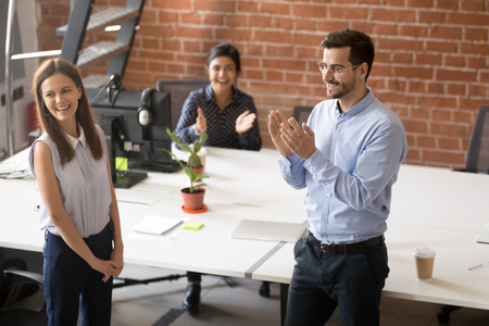 Friendly team leader, boss introducing to colleagues hired new member of team, newcomer, applauding to female employee, congratulating office worker with promotion, business success, rewardの写真素材