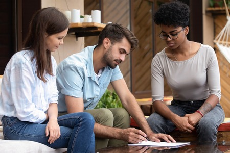 Serious focused man reading mortgage contract conditions, clients, customers consider real estate deal at meeting with realtor, consulting by financial advisor, investing money, prepare weddingの写真素材