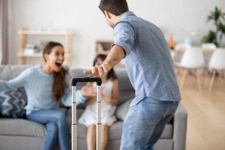 Cheerful loving mom and kid daughter excited to meet dad with suitcase coming home arriving from long trip, daddy hurrying to hug wife and child, welcome back father, happy family reunion conceptの写真素材