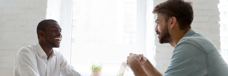 Horizontal photo diverse workers having fun at workplace discuss interesting project, share ideas, multiracial workmates friendship concept, banner for website header design with copy space for textの写真素材