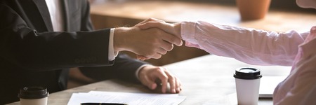 Horizontal photo close up hands two people businessman businesswoman shake hands, make good deal, hr manager greeting new employee hiring, services and client concept, banner for website header designの写真素材