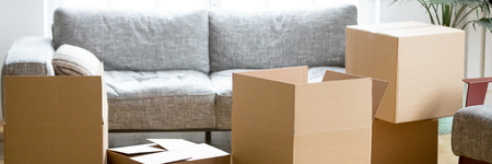 Horizontal photo heap of cardboard boxes with personal belongings in living room at moving...