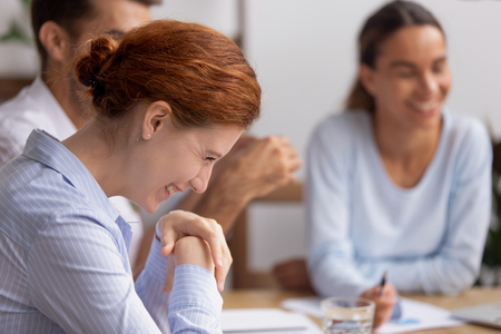 Happy cheerful business woman laughing at funny joke at group negotiations enjoy friendly team building talk at company meeting, smiling employee having fun positive emotions with office colleaguesの写真素材