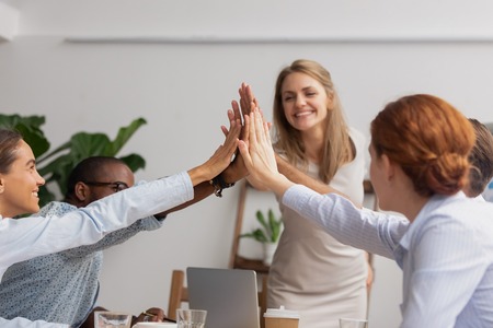 Reliable responsible happy diverse business team join hands give high five together, corporate...
