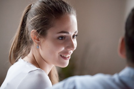 Smiling wife looking at beloved husband with love, care. Caucasian woman talking with man, focus on female. Couple having rest, discussing news, planning vacation. Support, love relationship conceptの写真素材