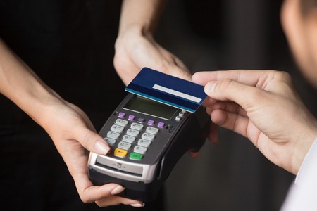 Customer pay bill in cafeteria or restaurant with contactless credit debit card NFC technology...
