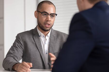 Serious african american bank investment advisor insurance broker lawyer in suit consulting client...