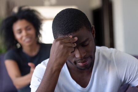 Millennial african couple quarrelling at home, close up focus in foreground american frustrated serious husband thinking about problems ignore his screaming hysterical wife. Break up, divorce conceptの写真素材