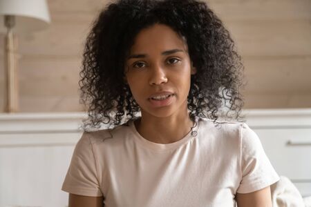 Close up african 30s woman look at camera make video call, having online job interview answers...