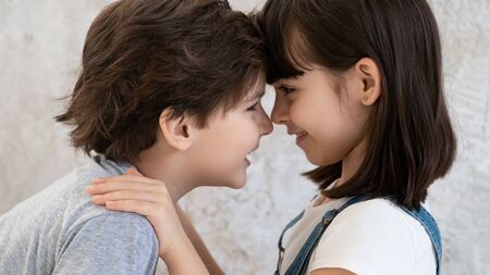 Funny little cute kids siblings brother with sister touching happy faces noses playing bonding at home, two adorable preschool small children boy and girl embracing cuddling together, side viewの写真素材