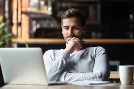 Thoughtful businessman think of online project looking at laptop at workplace, dreamy professional consider solution sit at work desk with computer, student search new idea inspiration in office cafeの写真素材