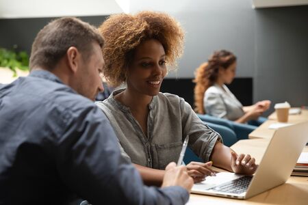 African american professional business woman mentor manager training caucasian male intern helping...