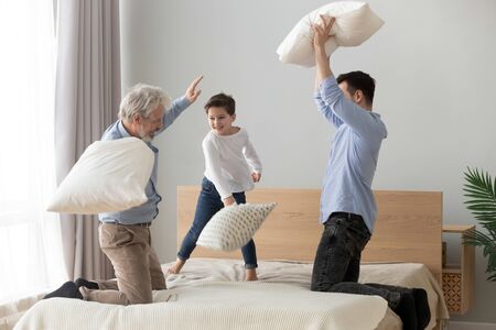 Happy multi 3 three generations men family old grandfather, adult son and little grandson having fun...