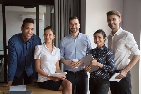 Team portrait of happy diverse professional corporate business people in office, smiling multicultural employees group looking at camera, international workers staff human resource posing togetherの写真素材