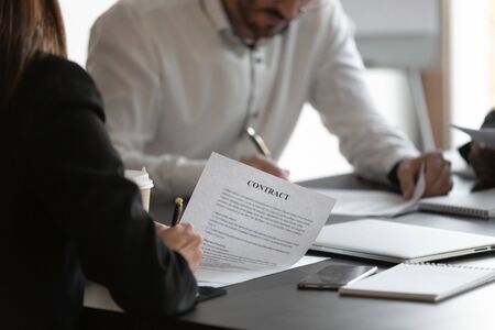 Female and male business partners sign contracts at meeting negotiation, man and woman put written...