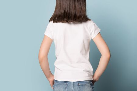 Close up image little brown-haired girl in white t-shirt back mock up. Concept young posing kid...