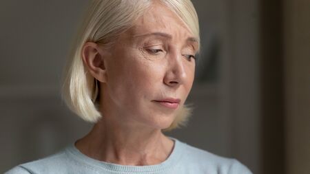 Close up face of elderly woman feels desperate abandoned and lonely having health or mental problem,...