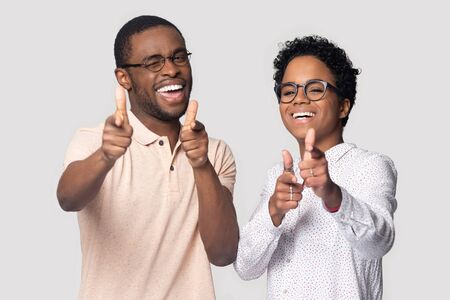 Happy joyful african american family couple looking at camera, showing at you, clients choice...
