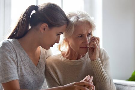 Loving adult female hug comfort caress crying elderly mother wipe tears use paper tissue, show...