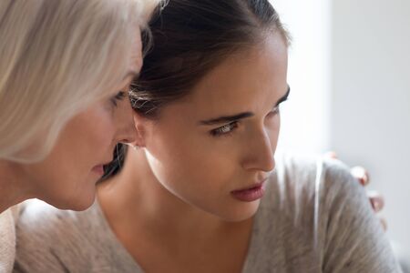 Close up of loving senior mother hug cuddle unhappy depressed millennial grownup daughter crying...