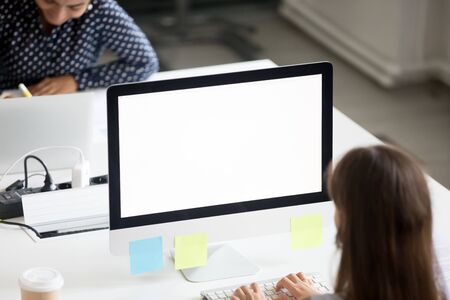 Focused millennial woman busy working on pc in office typing email letter or browsing internet online, female company worker using computer preparing project or writing report in coworking spaceの写真素材