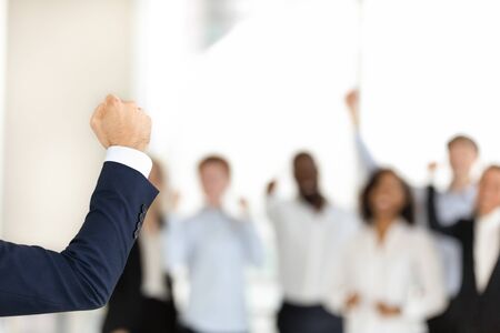 Successful confident businessman make speech show clenched fist demonstrate power and strength, excited diverse work team businesspeople support male leader together. Unity, leadership conceptの写真素材