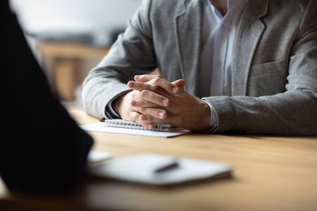 Two businessmen with clasped hands sitting opposite at table in boardroom close up, business confrontation and difficult negotiation, disagreement concept, opponents competitors dialogue debateの写真素材