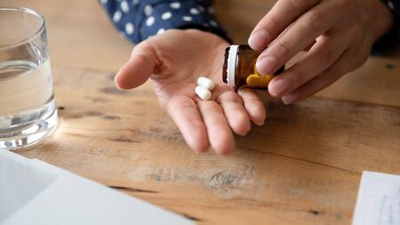 Close up of unhealthy young woman take antibiotics or antidepressant at home, unwell millennial...