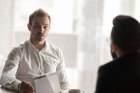 European man applicant answering of questions during job interview in office, business team working...