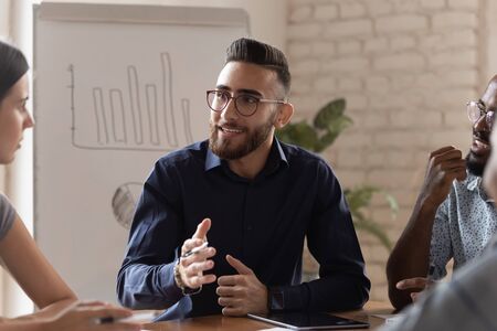Diverse business partners take part in negotiations at office boardroom listening successful millennial arab entrepreneur hold group meeting share new creative ideas, teamwork and partnership conceptの写真素材