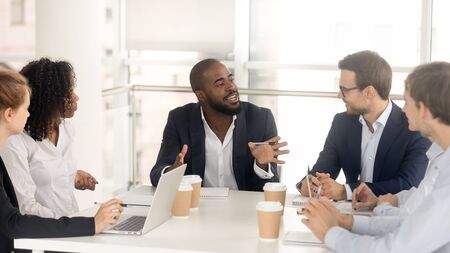 Black smiling male boss mentor leading corporate in team meeting. Fun african american businessman...