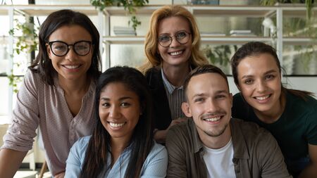 Portrait of diverse multiethnic smiling businesspeople look at camera pose for company group picture...
