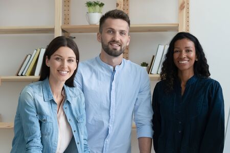 Group portrait of multiracial colleagues posing in modern office show unity and success, diverse multiethnic businesspeople coworkers look at camera posing in boardroom together, teamwork conceptの写真素材