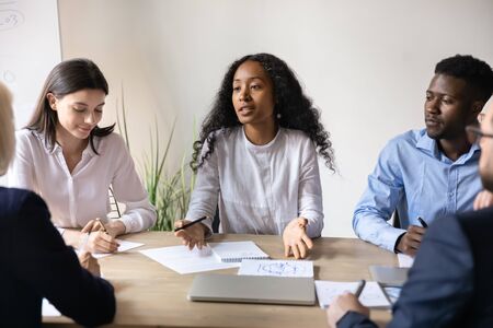 African American female leader head office meeting discuss business project with multiracial...