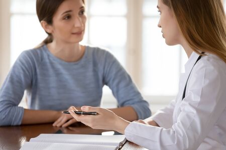 Young female doctor talk discuss prescription with female client in private clinic, woman GP or physician explain medical checkup results to patient at consultation in hospital, healthcare conceptの写真素材