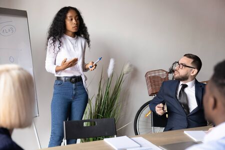 African American businesswoman mentor explaining project strategy at corporate meeting, giving flip...