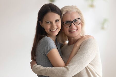 Portrait of smiling senior mother and adult daughter embrace show gratitude and love, happy caring...