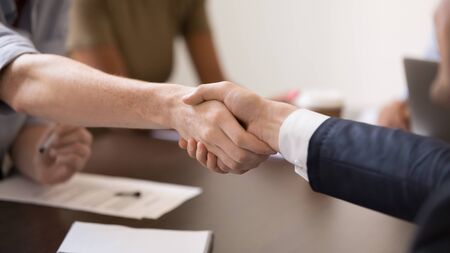 Close up business partners handshaking after successful negotiations wide horizontal image, making...