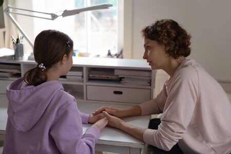 Loving mother comfort support unhappy depressed teen daughter suffering from school bullying, caring...