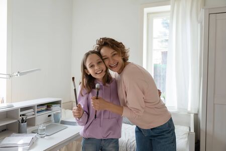 Portrait of smiling Caucasian mother and teenage daughter have fun in bedroom together, happy overjoyed loving mom and teen girl child enjoy family leisure weekend at home, bonding conceptの写真素材