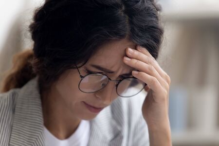 Close up of unhappy young Caucasian woman in glasses feel stressed disappointed with unpleasant bad news, upset female in spectacles suffer from relationships or work problems, depression conceptの写真素材