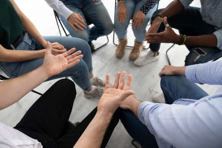 Above top close up view sitting in circle multi ethnic people participating at corporate team...