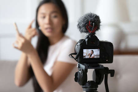 Close up focus on professional camera on stabilizer with young vietnamese woman beauty blogger on...