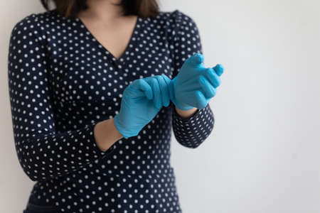 Close up of woman wear protective medical gloves from corona virus pandemics, crop of female try protecting rubber gear against covid-19 epidemics outbreak, coronavirus, health problems conceptの写真素材