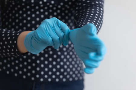 Crop close up of woman put medical rubber gloves against contagious Chinese corona virus pandemics, female wear protective hands gear from covid-19 epidemics, coronavirus, healthcare conceptの写真素材