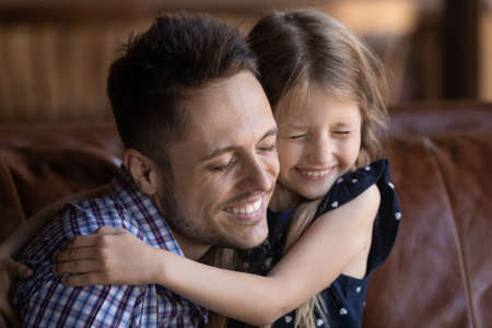 Cute little Caucasian girl child hug happy young father show love and gratitude, smiling small...