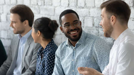 Close up smiling African American businessman wearing glasses chatting, diverse candidates...