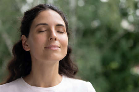 Close up of happy young Caucasian woman isolated on blurred background dream visualize with eyes...